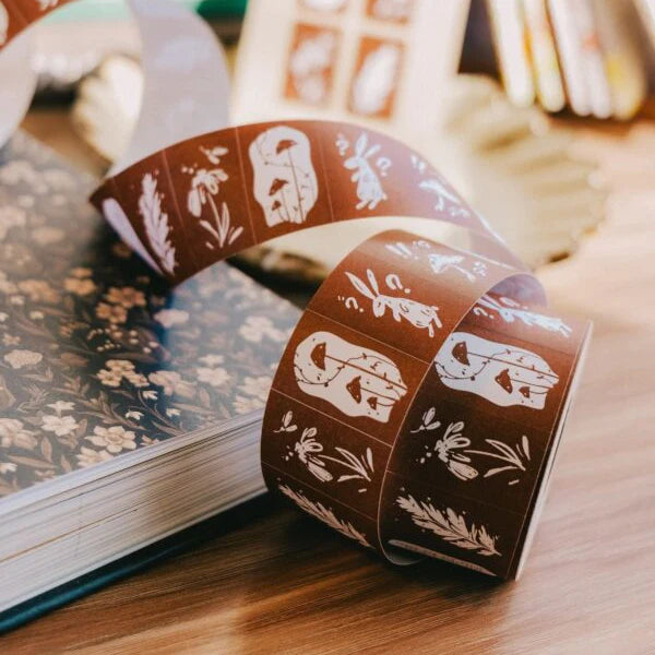Roll of Wonderland Rabbits Label Sticker Tape watercolor designs resting on a book