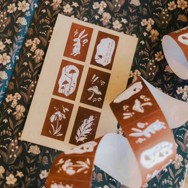 Set of stamps with floral and nature-themed designs on a floral-patterned fabric background.