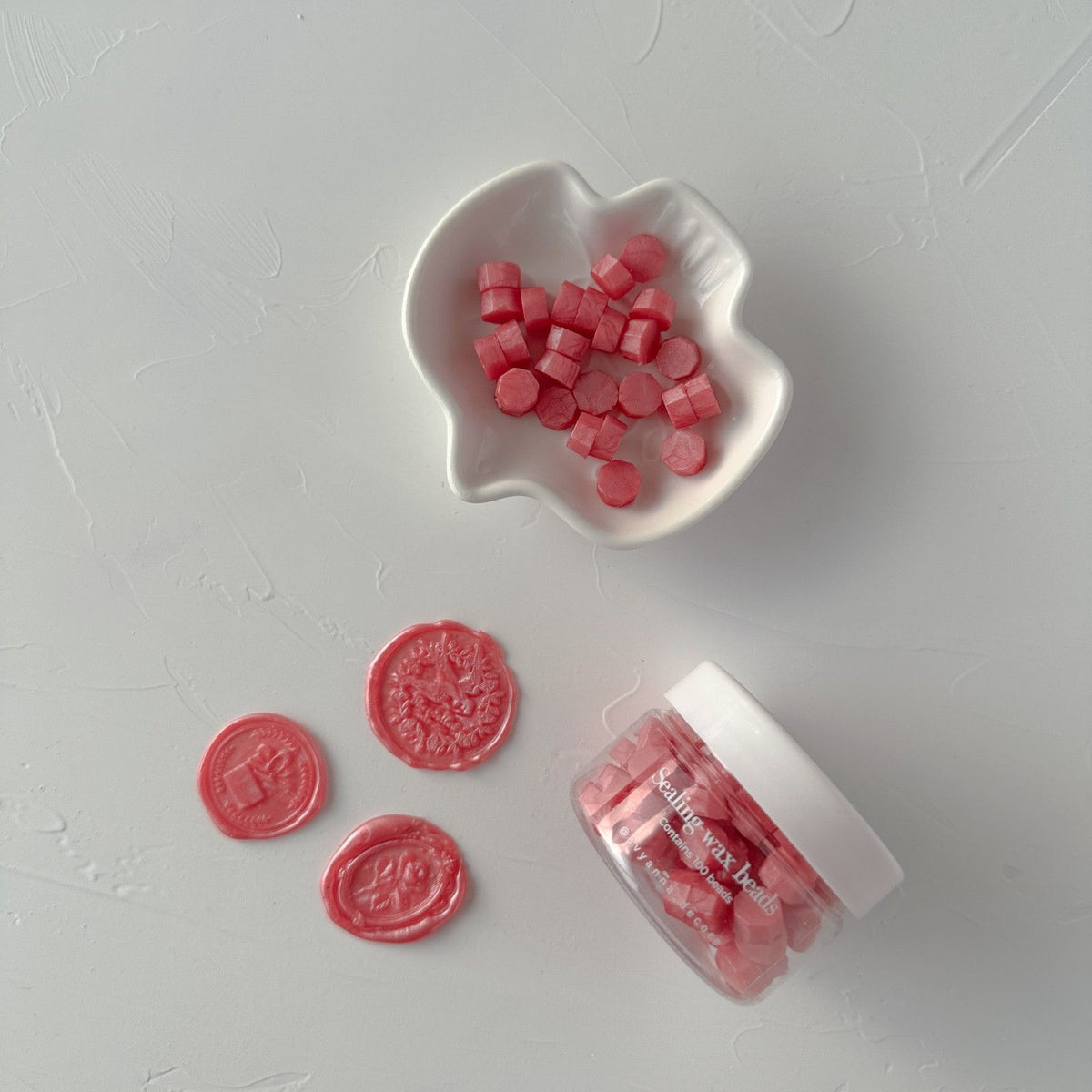 Young Wine Wax Beads in a deep wine-inspired shade gathered in a white bowl on a clean white surface