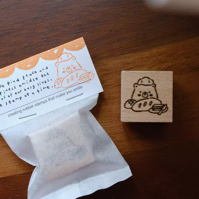 Foodie Bears Bread and Butter bear stamp beside its packaging on a warm wooden surface