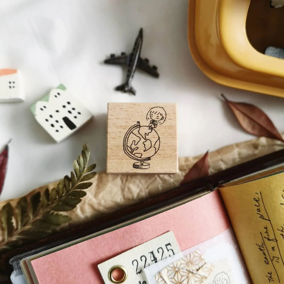 Mini Girls Around the Globe stamp with a girl holding a globe among stationery items