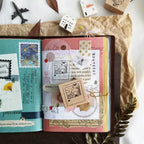 Open notebook with decorative pages and stamps on a white background