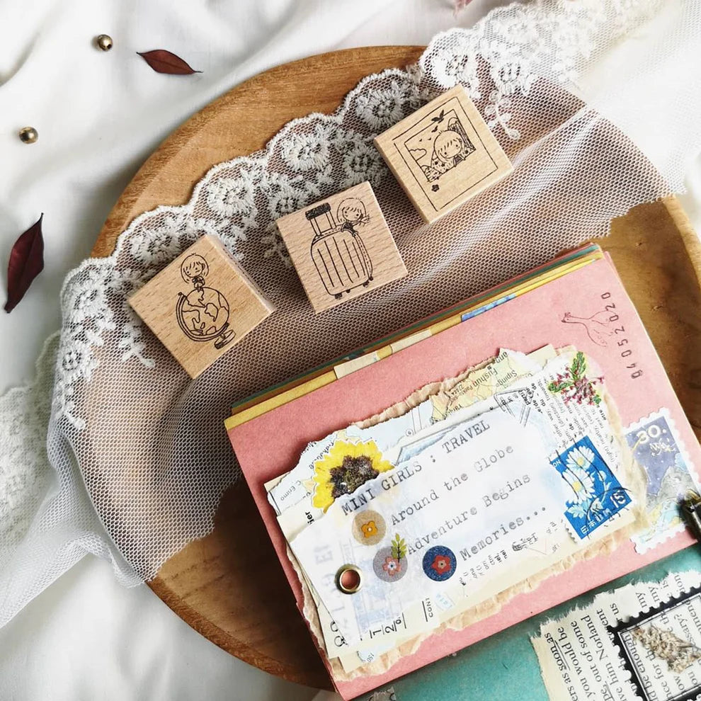 Mini Girls Travel Rubber Stamp set with stationery styled on a lace-draped surface