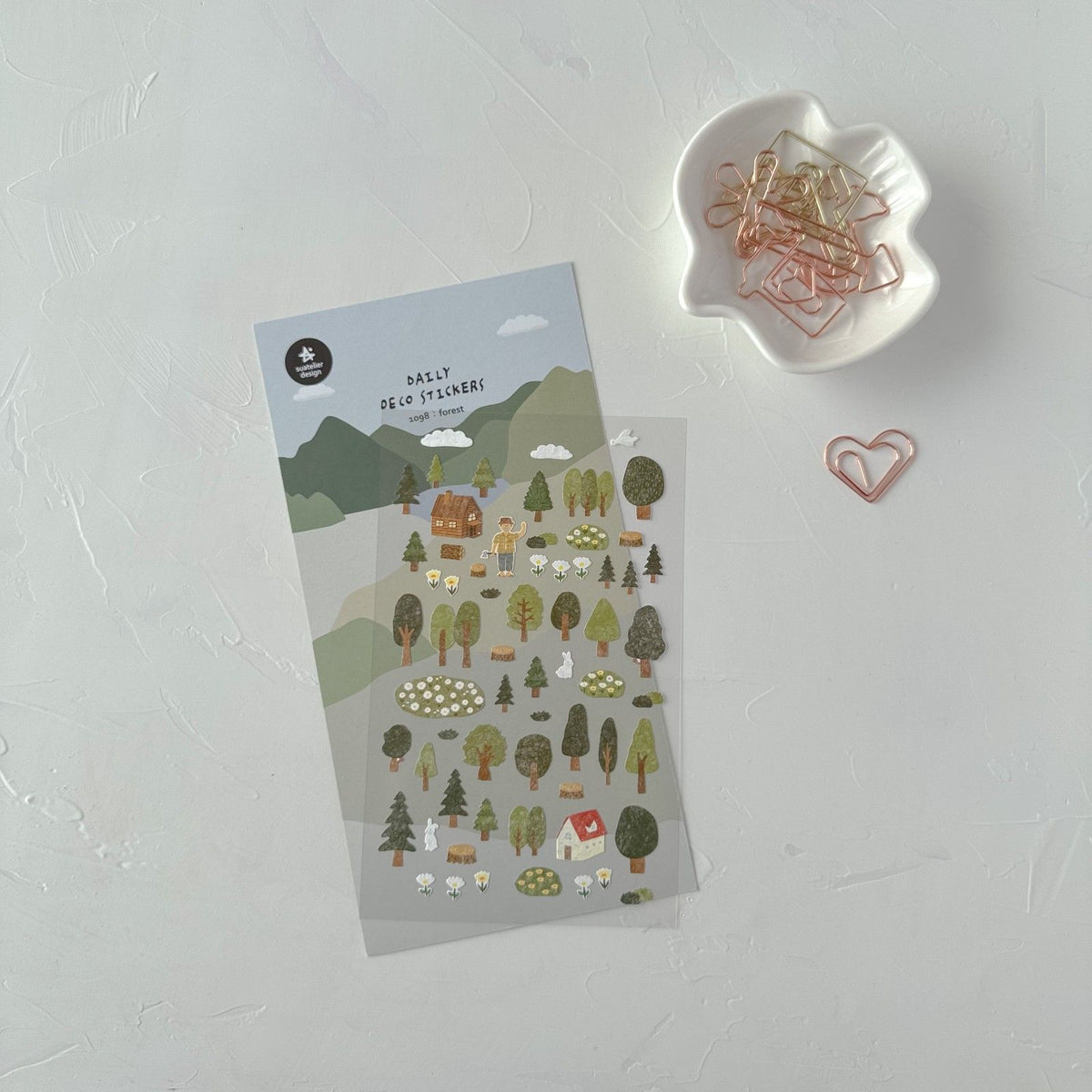 Pack of nature-themed stickers on a white surface with paper clips, from the Forest Sticker Sheet