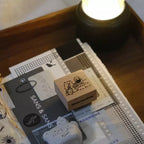 Wooden stamp with cartoon design on a stack of books with visible text