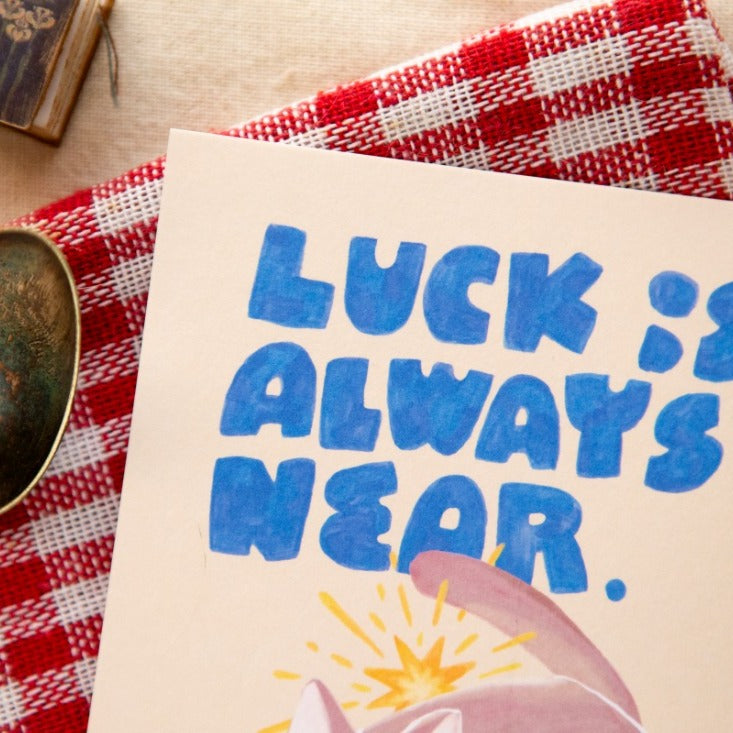 Little Break Post Card by OURS Studio — 'luck is always near' postcard on a checked tablecloth, for journaling