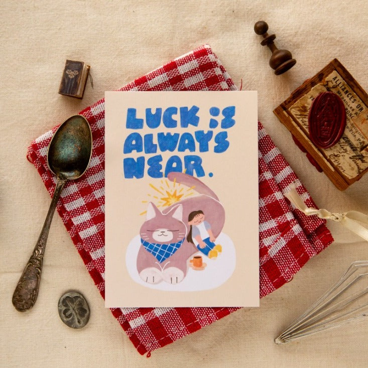 Little Break Post Card by OURS Studio — cat and girl 'luck is always near' postcard on red check, for journaling