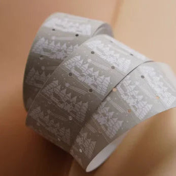 Two rolls of Winter Label Sticker Tape with cozy patterns on a warm beige background
