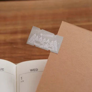 Winter Label Sticker Tape by Ivy Snow embossed label on an open notebook on a wooden desk