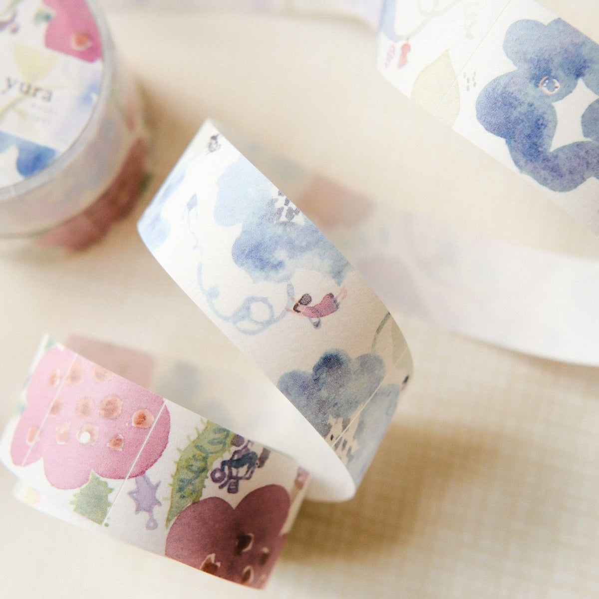 Decorative tape rolls with floral designs on a light background