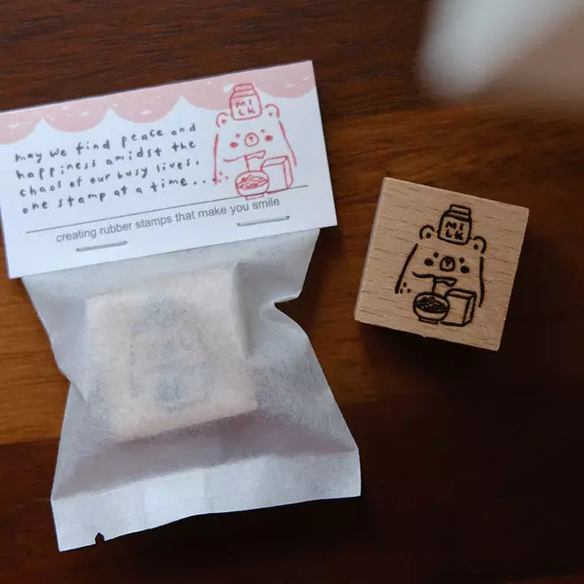 Foodie Bears Milk and Cereal bear stamp with a small tea bag on a warm wooden surface