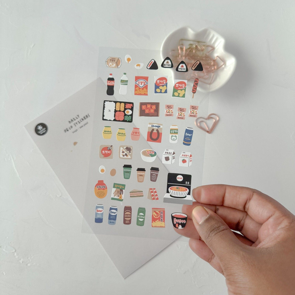 Hand holding a sheet of small stickers, from the See You! Sticker Sheet