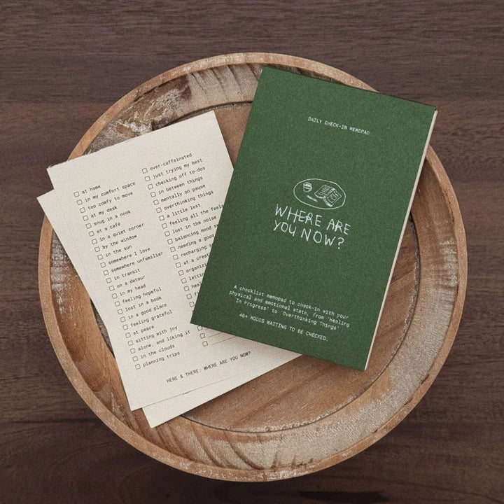Minimal daily check-in notepad with checklist pages placed on a wooden tray